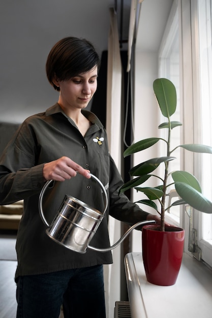 ミディアムショットの女性の散水植物