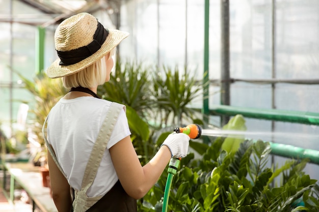 Medium shot woman watering plants