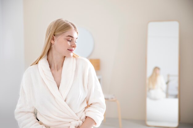 Medium shot woman wearing bathrobe