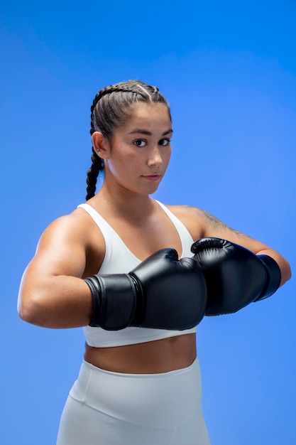 Medium shot woman wearing boxing gloves