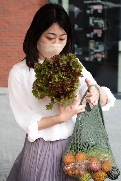 フェイスマスクを着用したミディアムショットの女性