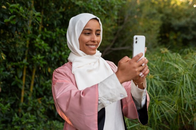 Foto gratuita donna di tiro medio che indossa halal all'aperto