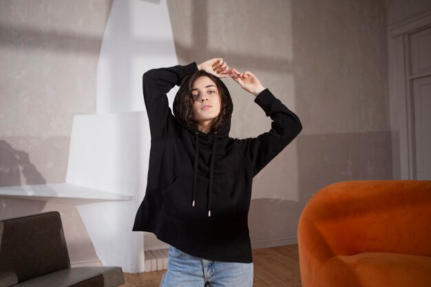 Medium shot woman wearing hoodie indoors