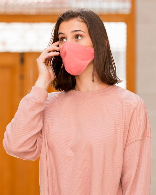 Medium shot woman wearing pink mask