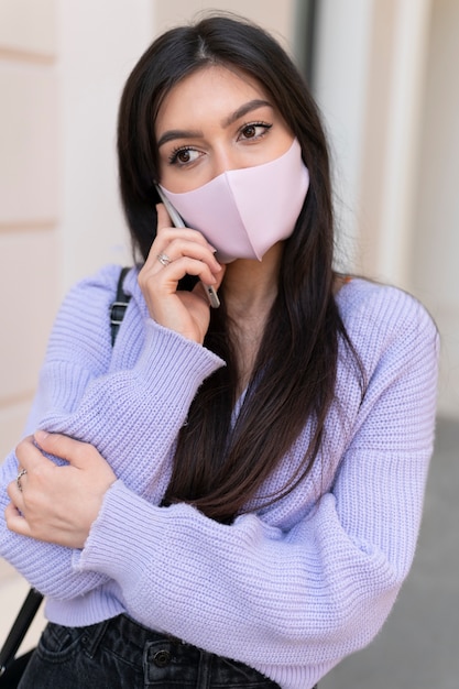 Free photo medium shot woman wearing pink mask