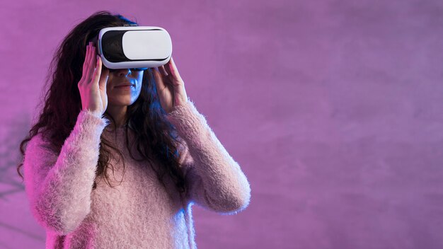 Medium shot of woman wearing a vr set copy space