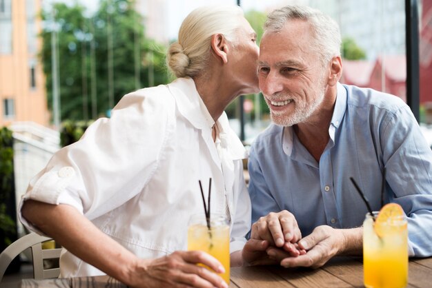 Medium shot woman whispering in man's ear