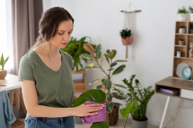 Medium shot woman wiping leaf