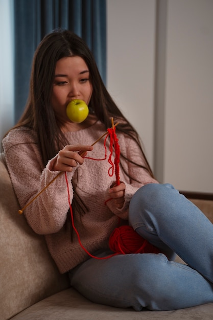 Medium shot woman with apple knitting