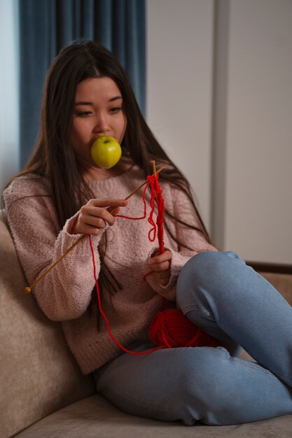 Medium shot woman with apple knitting