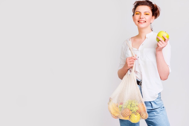 Free photo medium shot of woman with bag of fruits