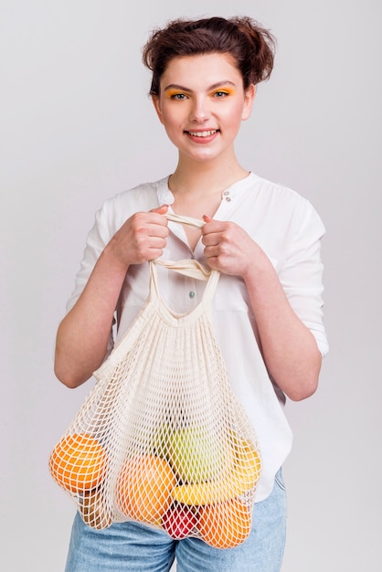 Medium shot of woman with bag of fruits