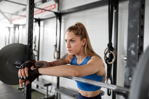 Medium shot woman with barbell