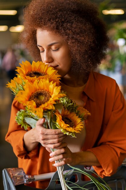 Medium shot woman with beautiful sunflowers