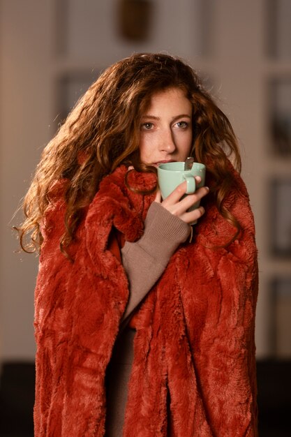 Medium shot woman with blanket and cup