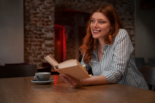 Женщина среднего роста с книгой в кафе