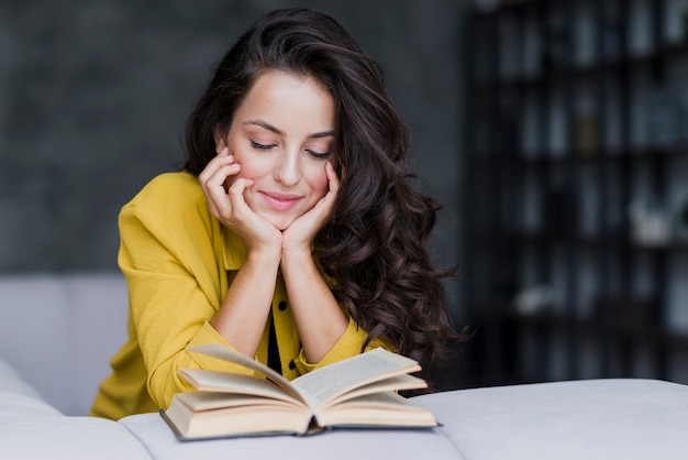 Medium shot woman with book indoors