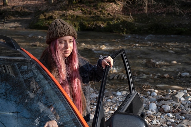 Medium shot woman with car outdoors