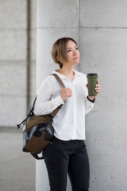 Женщина среднего кадра с кофейной фляжкой