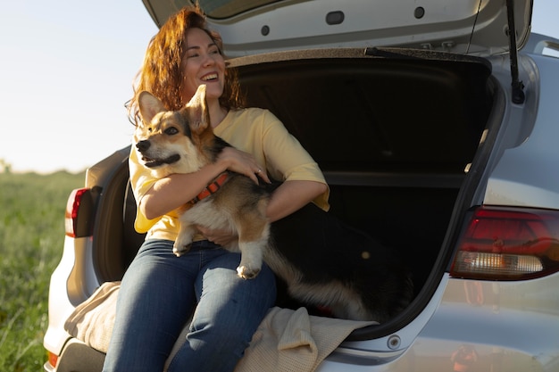 Medium shot woman with cute dog and car