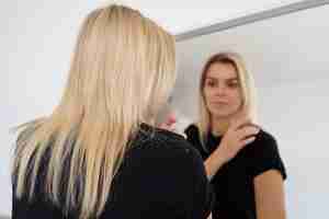 Free photo medium shot woman with dandruff looking in mirror