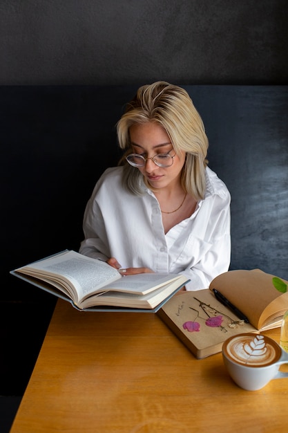Бесплатное фото Женщина среднего роста с дневником и книгой