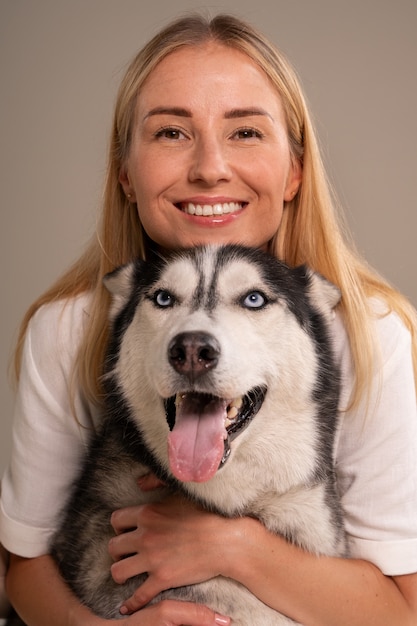 Donna di tiro medio con cane in studio