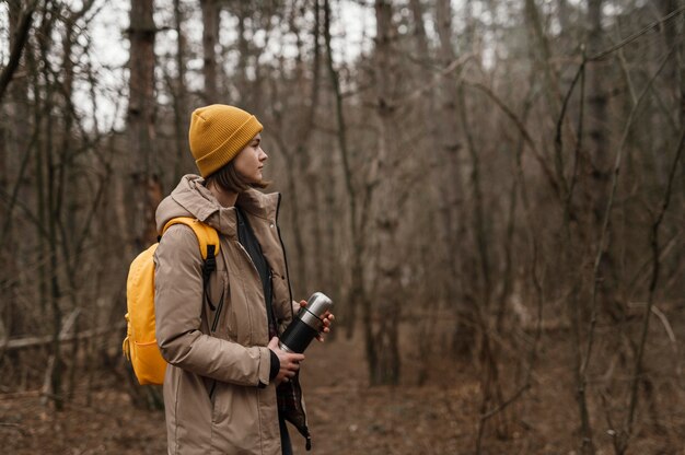 Medium shot woman with flask outdoors