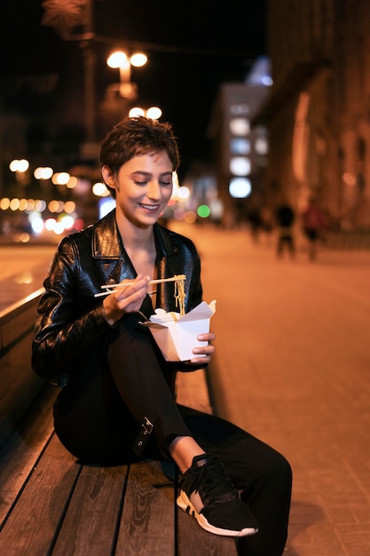 Medium shot woman with food on bench