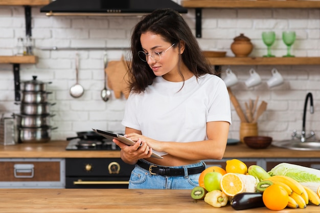 Medium shot woman with glasses and tablet