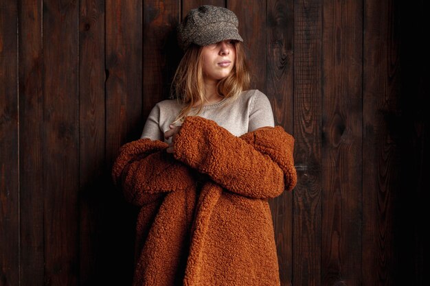 Medium shot woman with hat and coat indoors