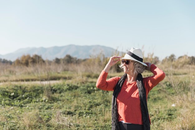 Medium shot woman with hat and sunglasses