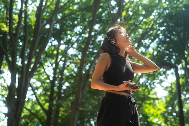 Medium shot woman with headphones in nature