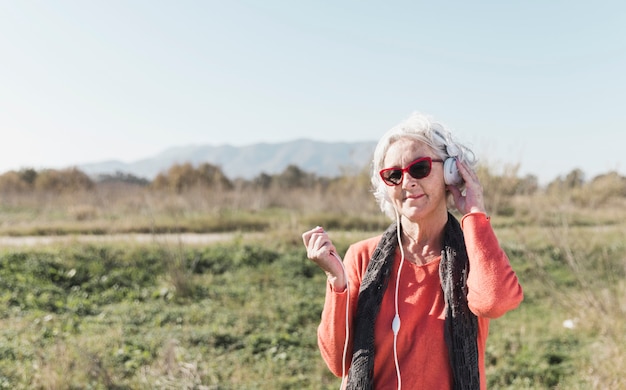 Medium shot woman with headphones outdoors