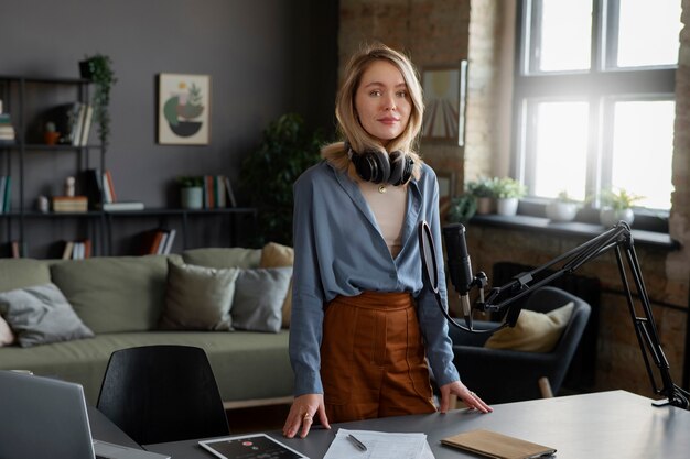 Medium shot woman with headphones at studio