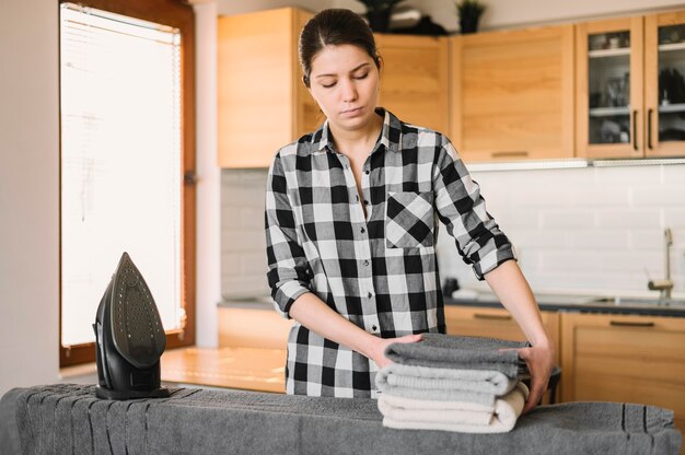 Medium shot woman with ironed towels