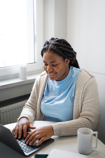 Free photo medium shot woman with laptop at home