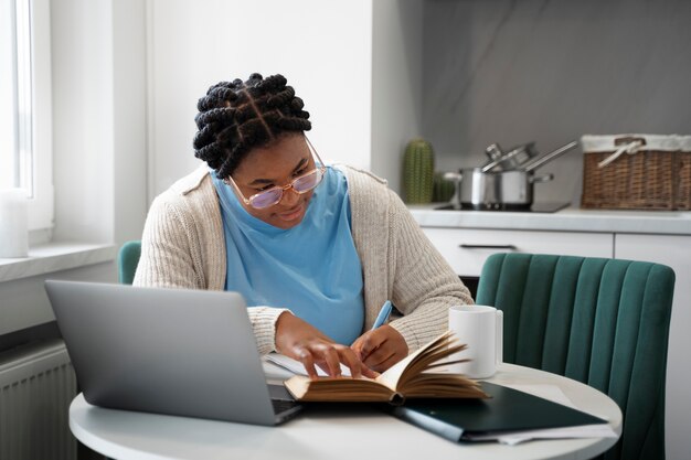 Medium shot woman with laptop at home