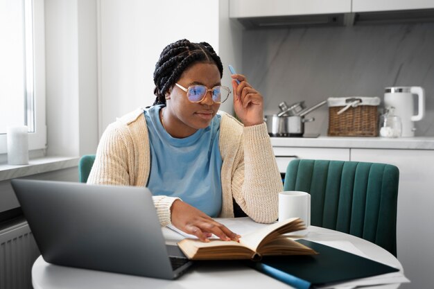 Medium shot woman with laptop at home