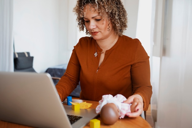 Foto gratuita donna del colpo medio con il computer portatile e vecchi oggetti