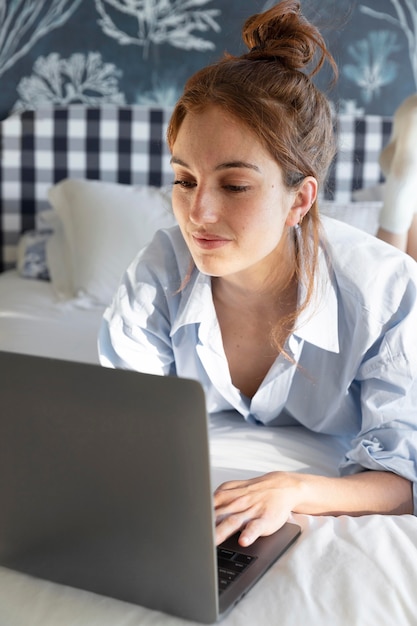 Donna del colpo medio con il computer portatile