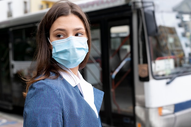 Foto gratuita donna a tiro medio con maschera all'aperto