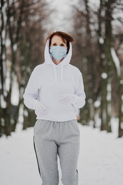 Medium shot woman with mask running