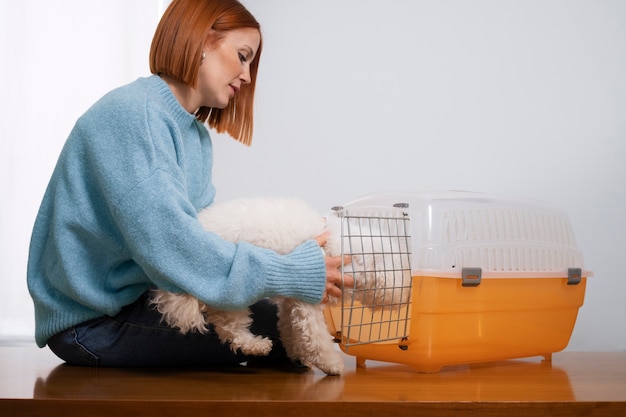 Бесплатное фото Женщина среднего роста с переноской для домашних животных