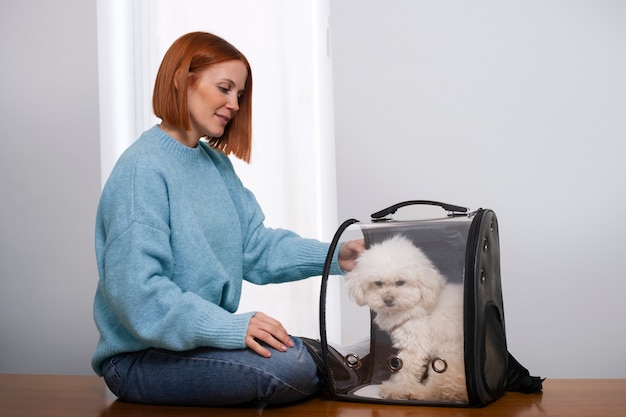 Бесплатное фото Женщина среднего роста с переноской для домашних животных