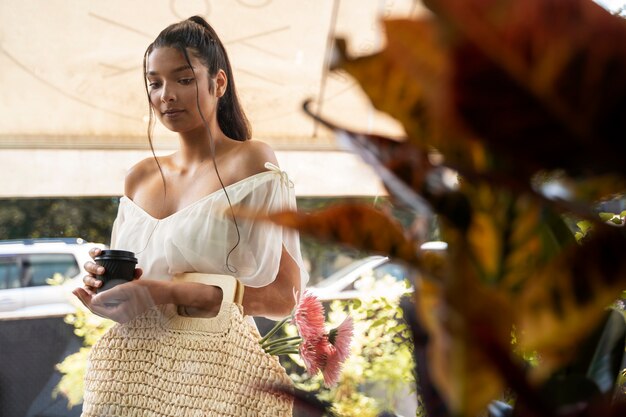 ピンクの花を持つミディアムショットの女性