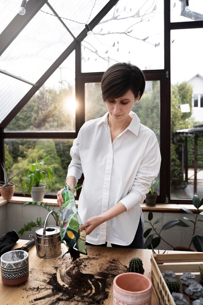 Medium shot woman with potting soil bag