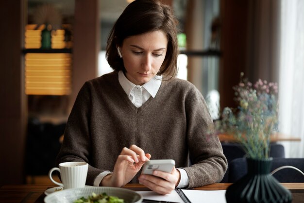 スマートフォンでミディアムショットの女性