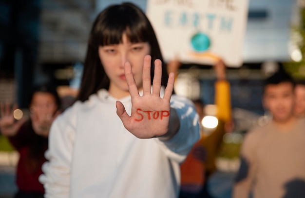 Free photo medium shot woman with stop message on palm