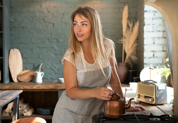 Medium shot woman with teapot looking away 